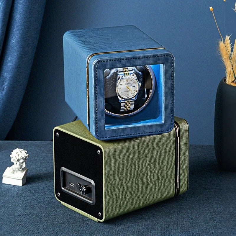 Watch winder with a watch inside on a dark surface with a blue background